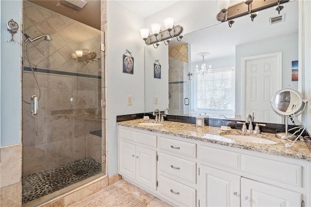 bathroom featuring a shower stall, double vanity, visible vents, and a sink