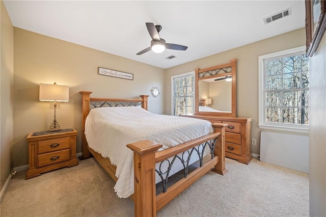 bedroom featuring multiple windows, light colored carpet, and visible vents