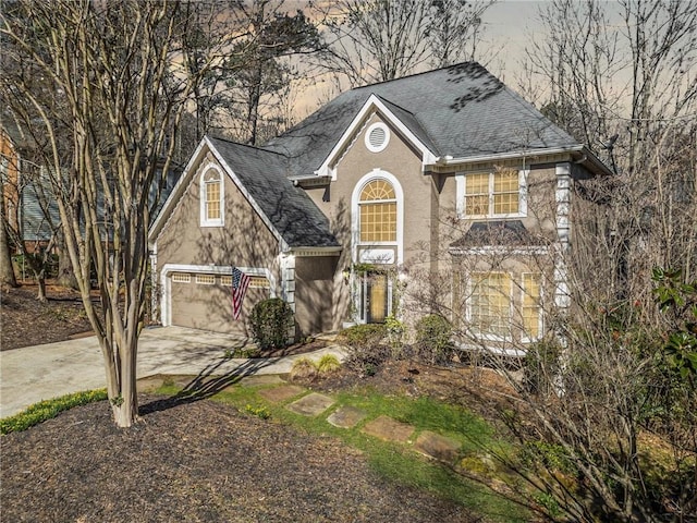 view of front of house featuring concrete driveway, a garage, roof with shingles, and stucco siding