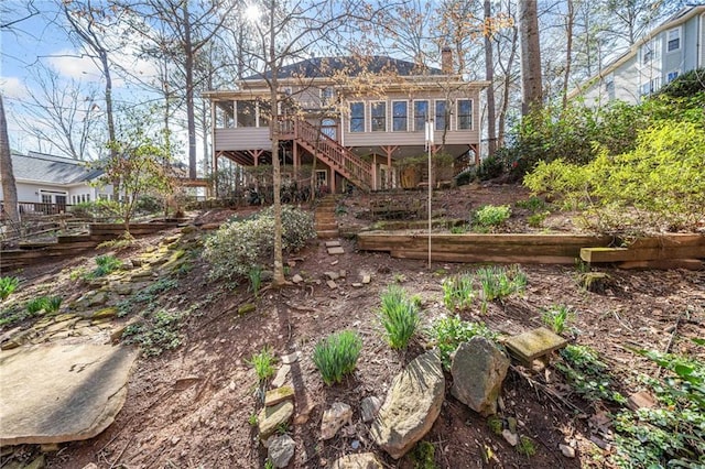 rear view of property featuring stairway and a sunroom