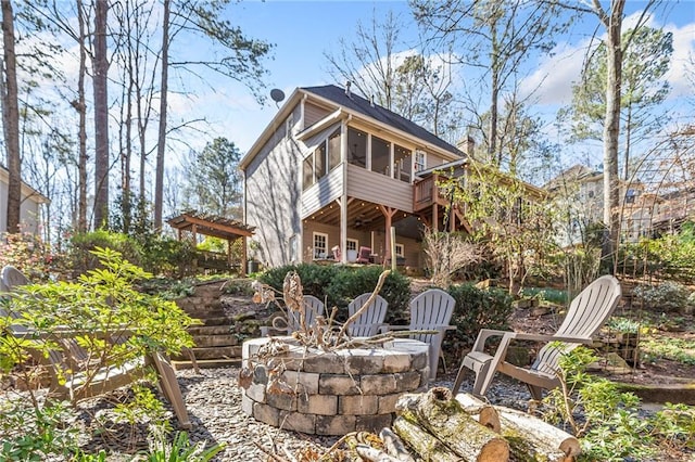 back of property featuring a pergola, an outdoor fire pit, a patio, and a sunroom