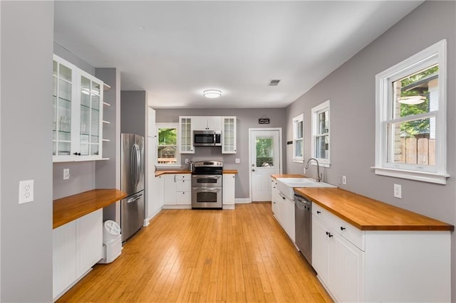 2486 Memorial Dr SE, Atlanta, GA 30317 - kitchen featuring appliances with stainless steel finishes, wood counters, a sink, light wood-style floors, and plenty of natural light