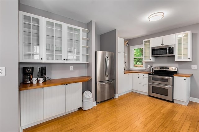 2486 Memorial Dr SE, Atlanta, GA 30317 - kitchen featuring appliances with stainless steel finishes, butcher block countertops, open shelves, and white cabinetry