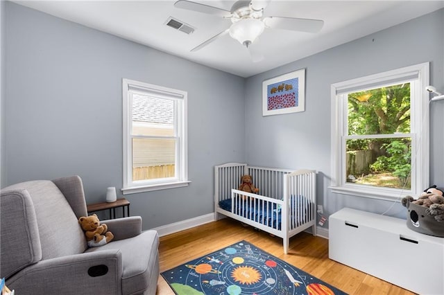 2486 Memorial Dr SE, Atlanta, GA 30317 - bedroom with multiple windows, wood finished floors, and a crib