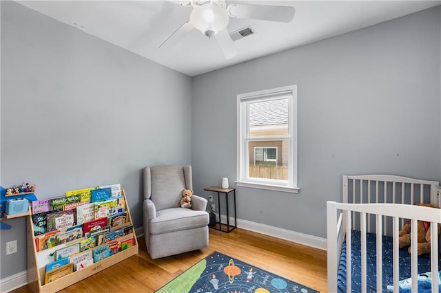 2486 Memorial Dr SE, Atlanta, GA 30317 - bedroom with wood finished floors, a nursery area, baseboards, and ceiling fan