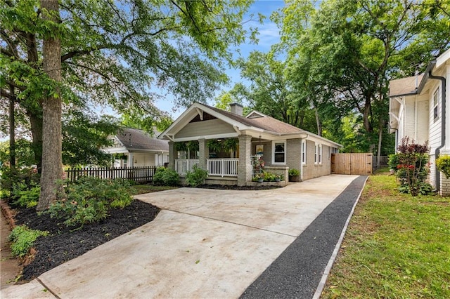 2486 Memorial Dr SE, Atlanta, GA 30317 - view of front facade with concrete driveway, a porch, a chimney, brick siding, and fence