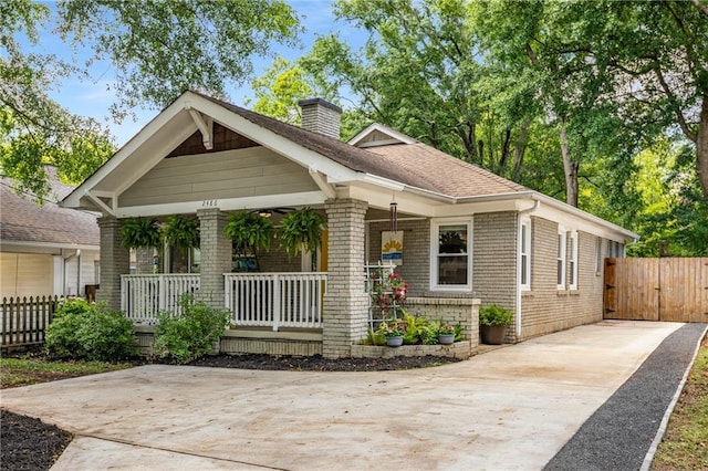 2486 Memorial Dr SE, Atlanta, GA 30317 - view of front of home with covered porch, concrete driveway, a chimney, and brick siding