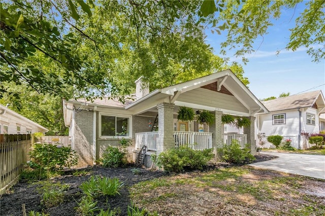 2486 Memorial Dr SE, Atlanta, GA 30317 - view of front facade featuring covered porch, brick siding, fence, and a chimney