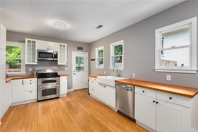 2486 Memorial Dr SE, Atlanta, GA 30317 - kitchen with wood counters, stainless steel appliances, a sink, and white cabinetry