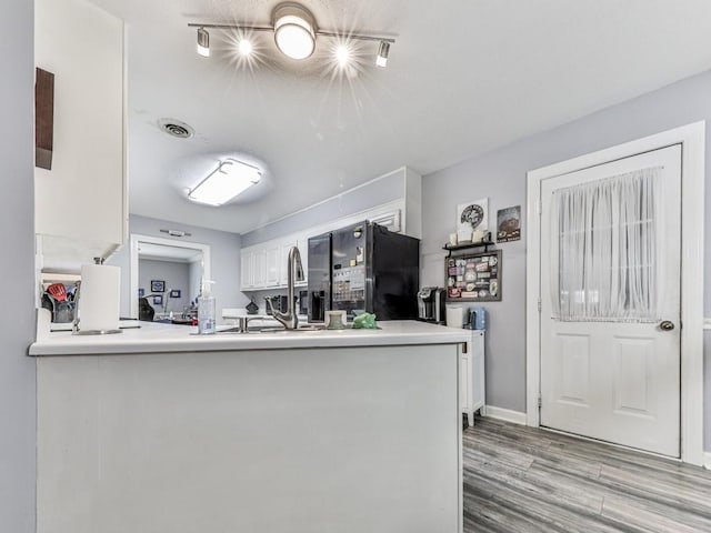 106 Warwick Way SE, Rome, GA 30161 - kitchen with freestanding refrigerator, white cabinets, light wood finished floors, and light countertops