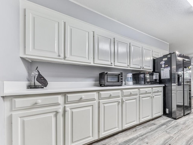 106 Warwick Way SE, Rome, GA 30161 - kitchen featuring black microwave, fridge with ice dispenser, white cabinets, light wood-style floors, and light countertops