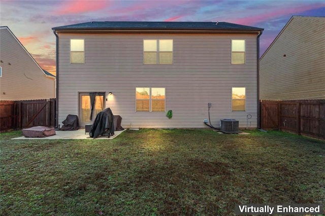 back house at dusk with a lawn and a patio area