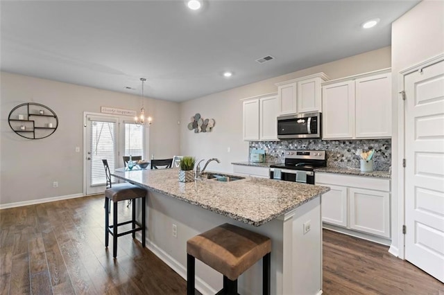 kitchen featuring an island with sink, white cabinets, and stainless steel appliances