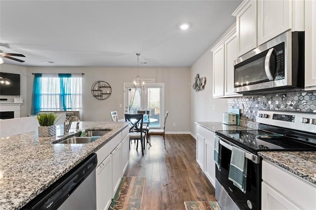 kitchen with stainless steel appliances, white cabinetry, plenty of natural light, and sink