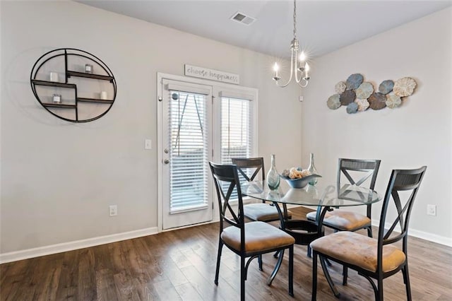 dining space with hardwood / wood-style floors and a chandelier