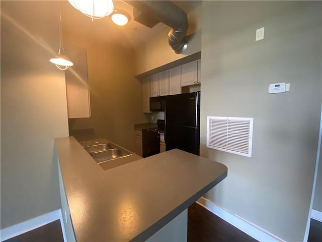 kitchen featuring black appliances, hanging light fixtures, white cabinets, sink, and kitchen peninsula