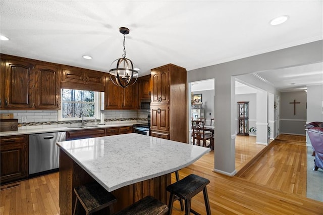 4286 Pool Rd, Winston, GA 30187 - kitchen featuring appliances with stainless steel finishes, a sink, a breakfast bar area, decorative backsplash, and a chandelier