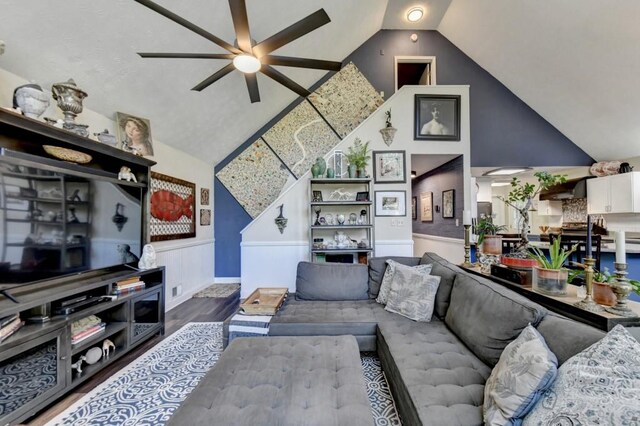 living room featuring ceiling fan, wood-type flooring, and lofted ceiling