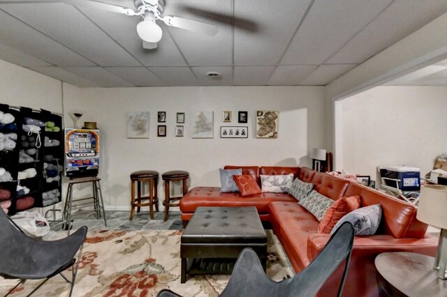 living room with a paneled ceiling and ceiling fan