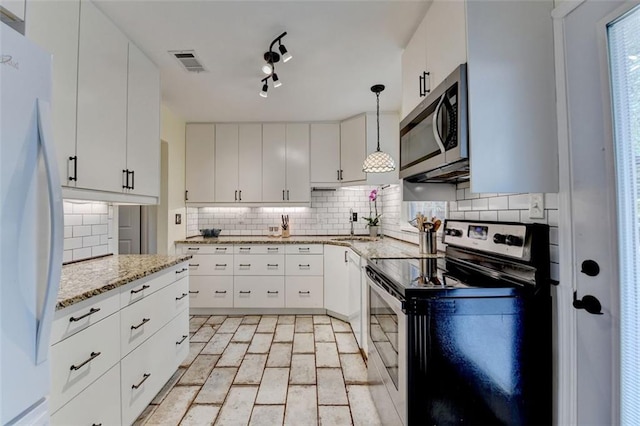 kitchen with visible vents, brick floor, white cabinets, tasteful backsplash, and stainless steel appliances
