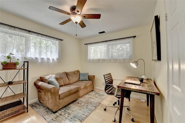 office space featuring baseboards, ceiling fan, and wood finished floors