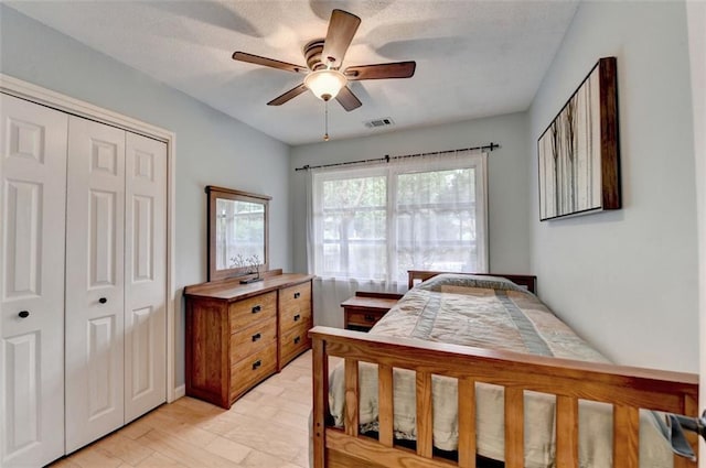 bedroom with a closet, a ceiling fan, and visible vents
