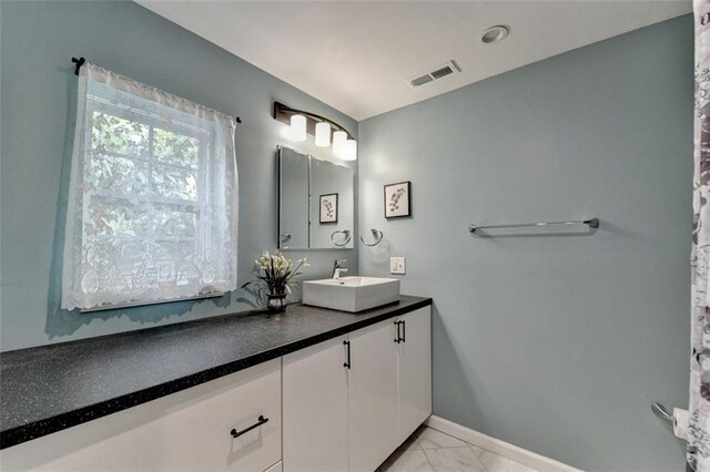 bathroom featuring baseboards, visible vents, marble finish floor, and vanity
