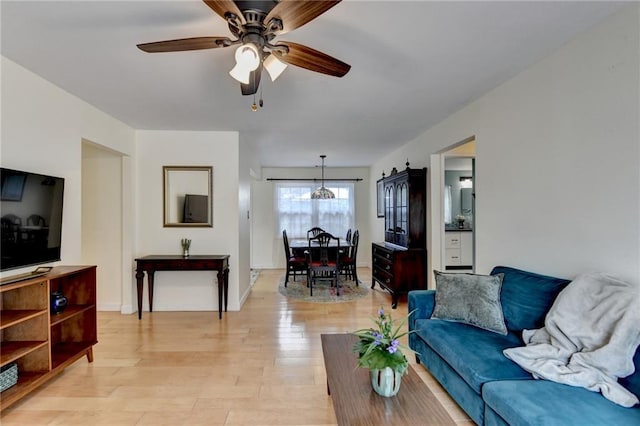 living room with light wood-style floors and a ceiling fan