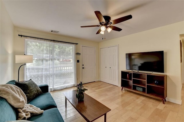 living room with visible vents, ceiling fan, and light wood-type flooring