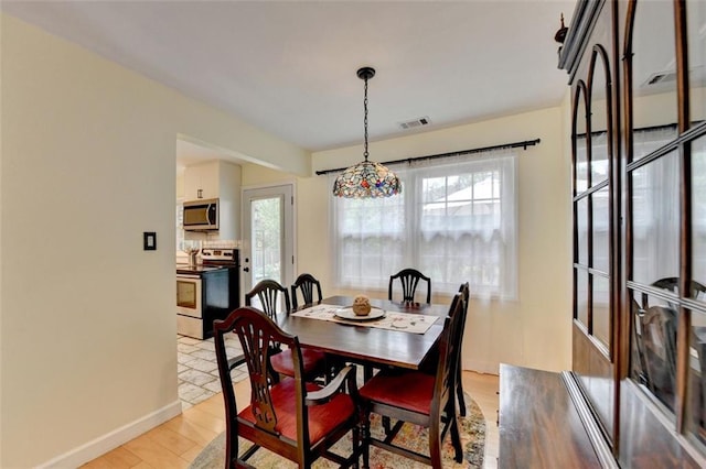 dining room featuring visible vents, baseboards, a wealth of natural light, and light wood-type flooring