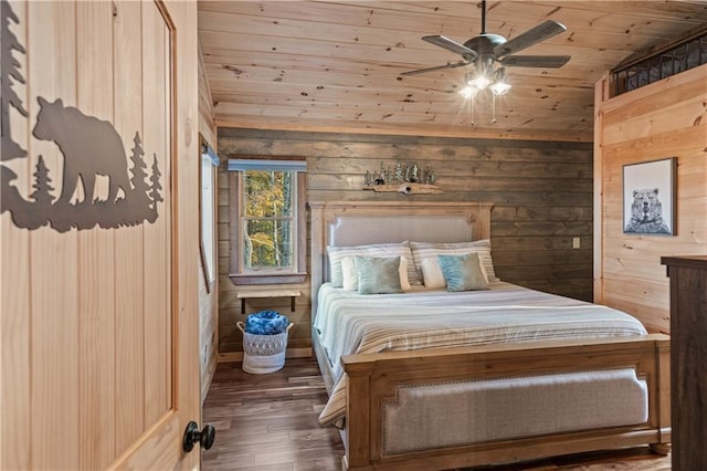 bedroom with vaulted ceiling, wood walls, ceiling fan, wood finished floors, and wooden ceiling