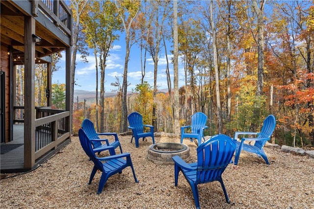 view of yard with a fire pit and a view of trees