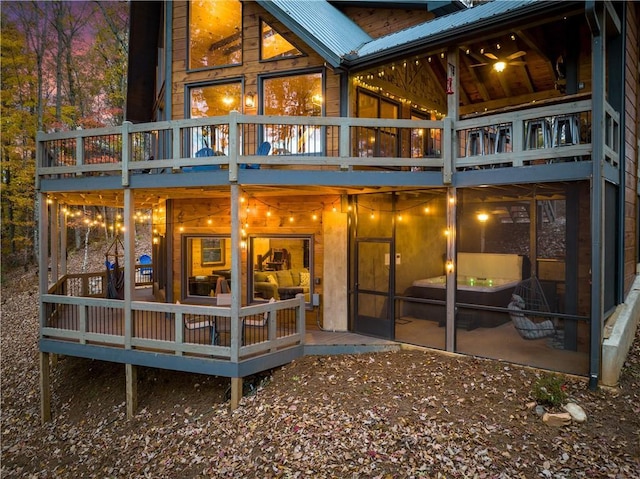 back of property featuring metal roof and a wooden deck