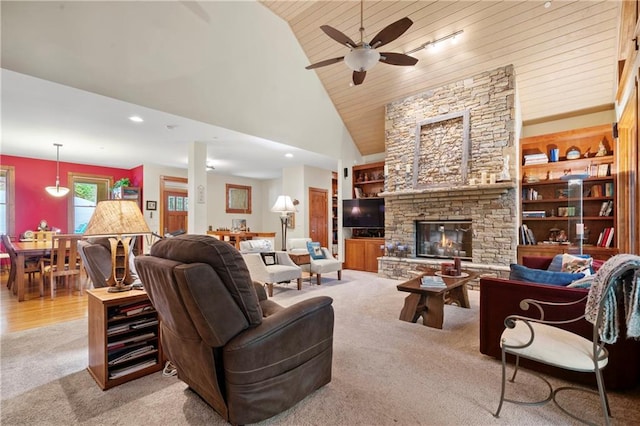 living room featuring a stone fireplace, built in features, high vaulted ceiling, light colored carpet, and wood ceiling