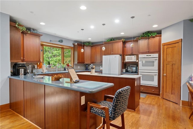 kitchen with pendant lighting, a kitchen breakfast bar, a center island, tasteful backsplash, and black appliances