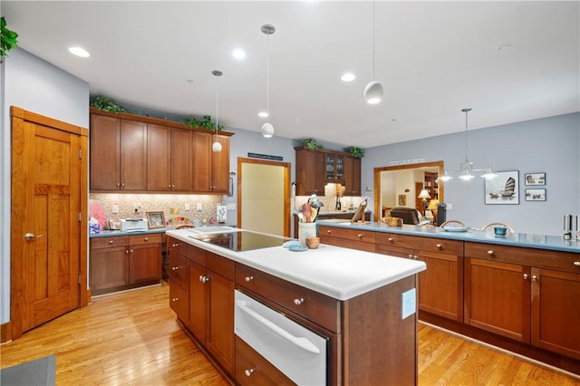 kitchen featuring light hardwood / wood-style flooring, a center island, black electric stovetop, and decorative light fixtures