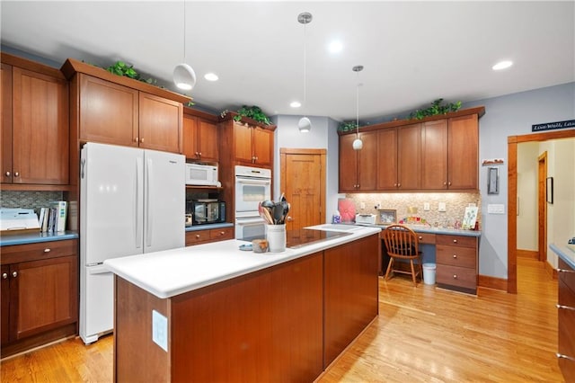 kitchen with light hardwood / wood-style flooring, hanging light fixtures, a center island, tasteful backsplash, and black appliances