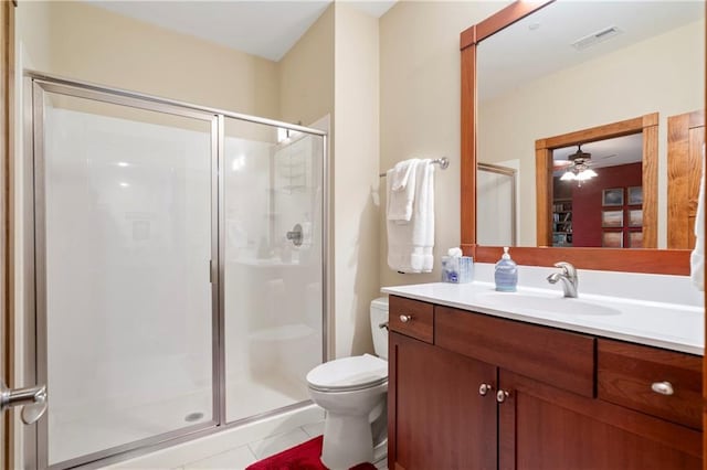 bathroom featuring tile patterned flooring, vanity, a shower with shower door, and toilet