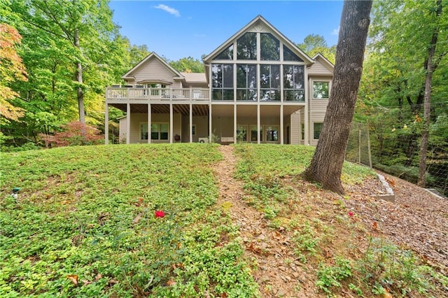 rear view of house with a wooden deck and a sunroom