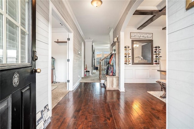 foyer entrance featuring hardwood / wood-style flooring, beam ceiling, and crown molding