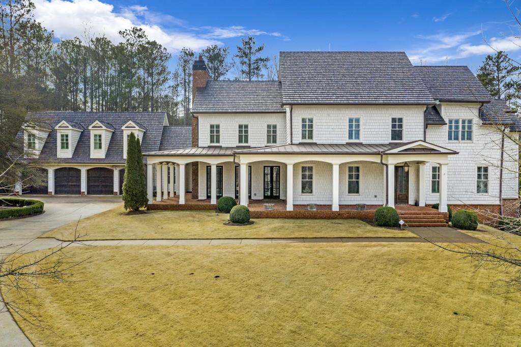 view of front of home featuring a porch, a garage, and a front yard