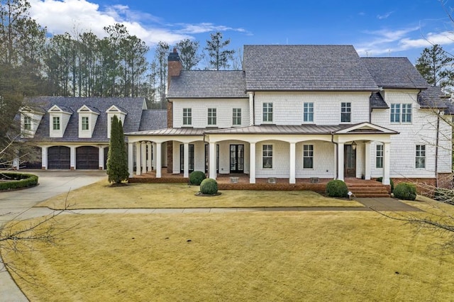 view of front of home featuring a porch, a garage, and a front yard