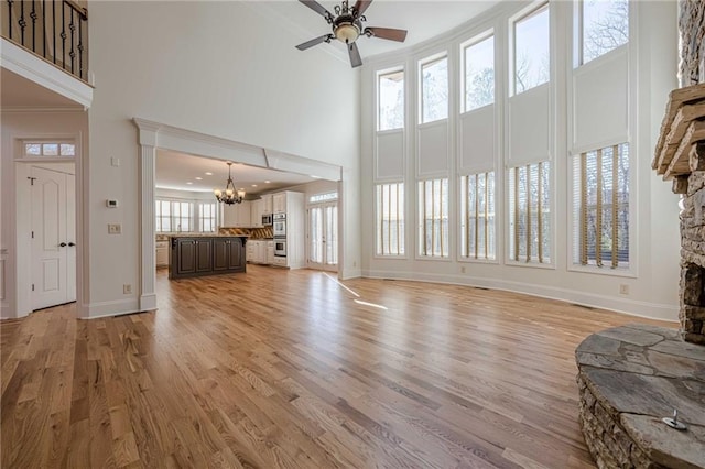 living room featuring a wealth of natural light, ornamental molding, and light wood-type flooring