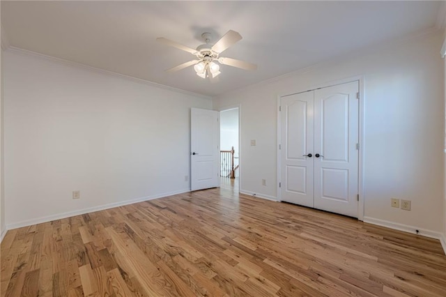 unfurnished bedroom featuring ceiling fan, ornamental molding, a closet, and light hardwood / wood-style flooring