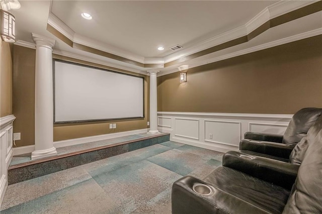 home theater featuring ornamental molding, a raised ceiling, and ornate columns