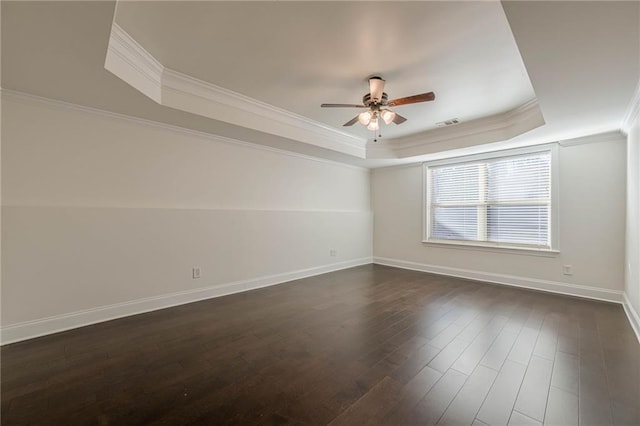 empty room with crown molding, ceiling fan, dark hardwood / wood-style flooring, and a raised ceiling