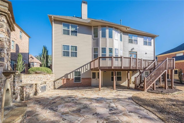 rear view of property with a wooden deck and a patio area