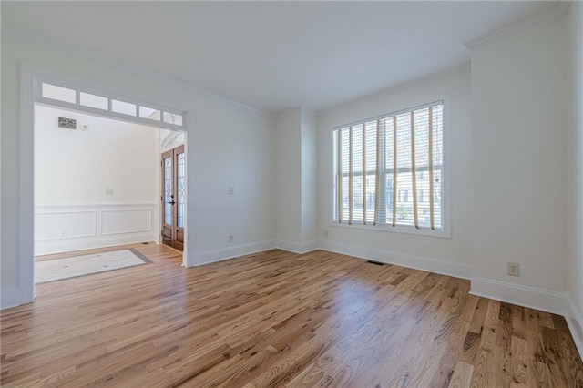 spare room with french doors, ornamental molding, and light hardwood / wood-style floors