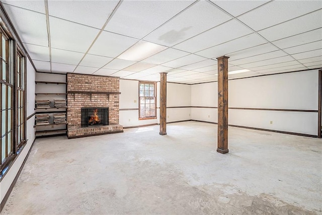 1703 W Nancy Creek Dr NE, Brookhaven, GA 30319 - unfurnished living room with unfinished concrete floors, a brick fireplace, a paneled ceiling, and baseboards