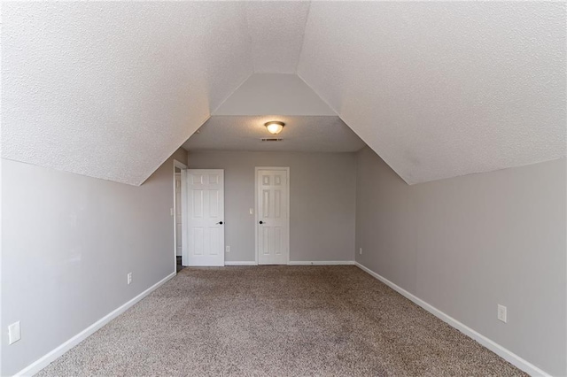 7384 Birch Hollow Pl, Douglasville, GA 30134 - additional living space featuring a textured ceiling, vaulted ceiling, baseboards, and carpet flooring